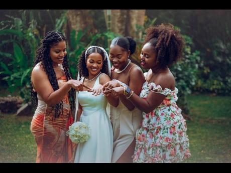 The bridal party in awe of Kady-Ann’s (second left) wedding ring. From left: Nastassia Rowe, Audra Wilson and Shelly-Ann Higgins.