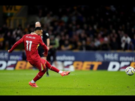 Liverpool's Mohamed Salah scores his side's second goal of the game during an English Premier League football match against Wolverhampton Wanderers at the Molineux Stadium in Wolverhampton, England, Saturday, September 28, 2024.