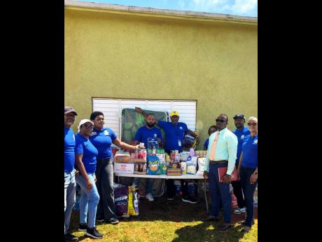 Credit union volunteers deliver goods from the 40-foot container to the home in Southfield. Manager Richard Aikens (far right) is pictured receiving the supplies on behalf of the boys.