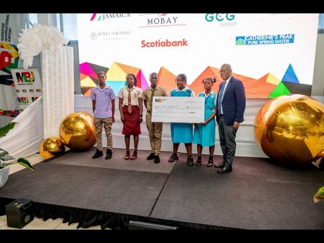 Saluting commitment and endurance: Senator Charles Sinclair (right) shares a photo op with a group of secondary awardees after presenting them with the symbolic cheque for J$30 million during the MBJ Foundation’s Charity Run/Walk Grant Award Ceremony at 