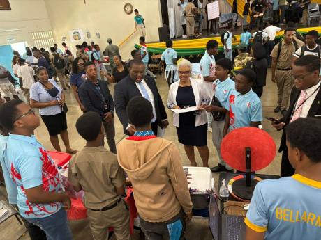 Credit: Contributed Senator Marlon Morgan, parliamentary secretary in the Ministry of Education, Skills, Youth and Information, engages with a group of students at the STGC Teen Biz Expo 2026 as St George’s College Principal Margaret Campbell looks on.
