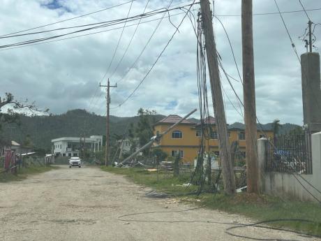 Cables hang from a utility pole and trail along the roadside in Carawina, Westmoreland.