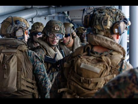 This image from video provided by United States Central Command shows US Sailors and Marines aboard USS Tripoli (LHA 7) arriving in the U.S. Central Command area of responsibility on March 27, 2026. (US Central Command via AP)
