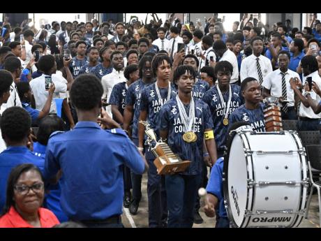 Jamaica College athletes march into the auditorium for Monday’s celebrations following their victory in the ISSA/GraceKennedy Boys’ Championships on the weekend.