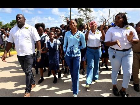 Shanoya Douglas (centre) enters Holland High School grounds in Trelawny to a hero’s welcome on Monday, following her record-breaking performance at the 2026 ISSA GraceKennedy Boys’ and Girls’ Athletics Championships.