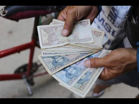 An ice cream street vendor shows his Cuban pesos in Havana, Cuba, April 20, 2024. 
