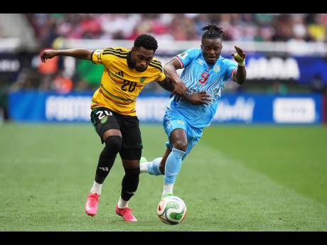 Jamaica’s Renaldo Cephas (left) and DR Congo’s Brian Cipenga vie for the ball during the Intercontinental World Cup Playoff final in Guadalajara, Mexico yesterday.