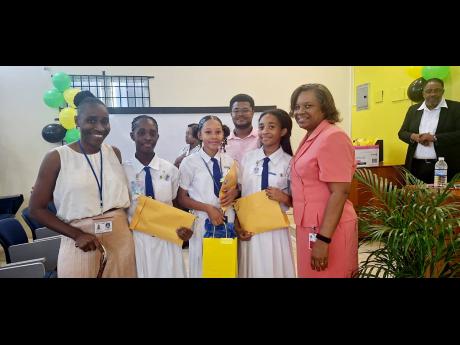 First-place winners Amia Thomas, Miaya Stewart and Zhanna Whyte of Immaculate Conception High School share a photo with their teacher, Danielle Francis (left), and Professor Marcia Roye (right), associate dean for Graduate Studies and Research in the Facul