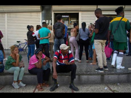 People wait their turn to enter a bank in Havana, Cuba, Wednesday, April 1, 2026. (AP Photo/Ramon Espinosa)