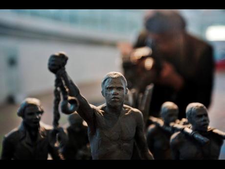 A man photographs a maquette of a statue, at City Hall, London.