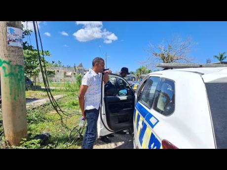 Member of Parliament Dwayne Vaz speaks with members of the Jamaica Constabulary Force after addressing residents in Hertford amid ongoing concerns about road conditions.