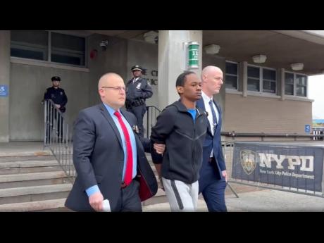 Zahir Davis, 18, getting walked out of the 113th Precinct in Queens, New York, on Saturday.