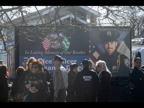 New York Police Department Officer Jonathan Diller is on a screen during his funeral service at Saint Rose of Lima R.C. Church in Massapequa Park, N.Y., March 30, 2024. (AP Photo/Jeenah Moon, File)