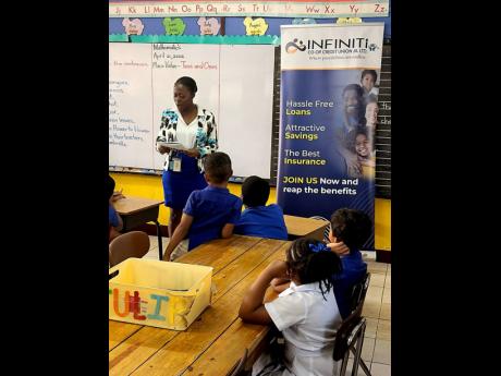 An Infiniti staff volunteer reads ‘Tommy and the Money Tree’ to students at the Mount Alvernia Preparatory School during April’s Financial Literacy Month.
