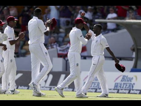 Credit: AP Teammates greet West Indies' Kemar Roach (right) at the end of the first innings of day two of their first Test match against England at the Kensington Oval in Bridgetown, Barbados, this afternoon. (AP Photo/Ricardo Mazalan)